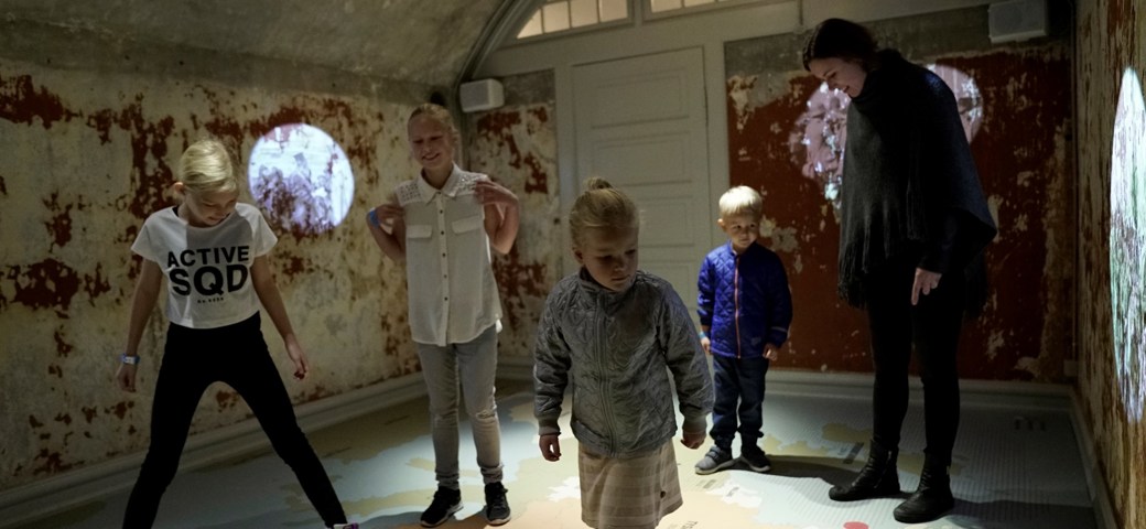Familie står på kort over Europa i udstilling på Mosede Fort