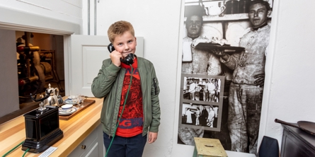Dreng taler i telefon i udstillingen på Mosede Fort