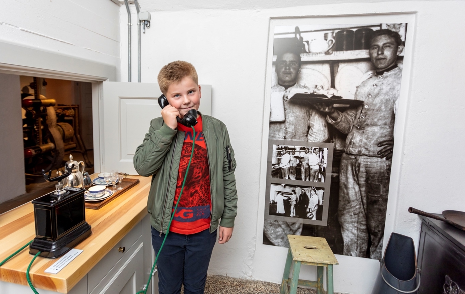 Dreng taler i telefon i udstillingen på Mosede Fort