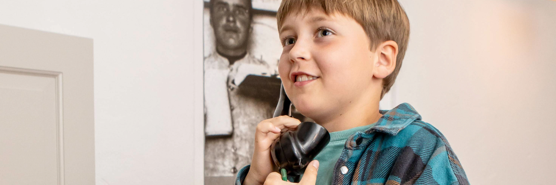 Dreng snakker i gammeldags telefon
