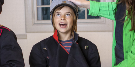 Dreng iført soldateruniform er glad