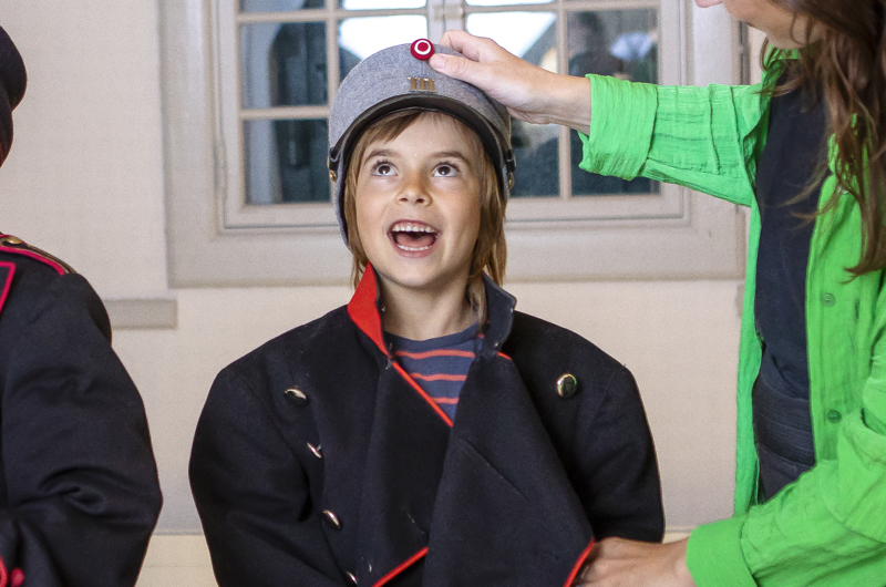 Dreng iført soldateruniform er glad